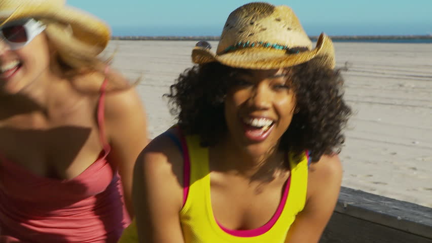 Two women friends at the beach in cowboy hats