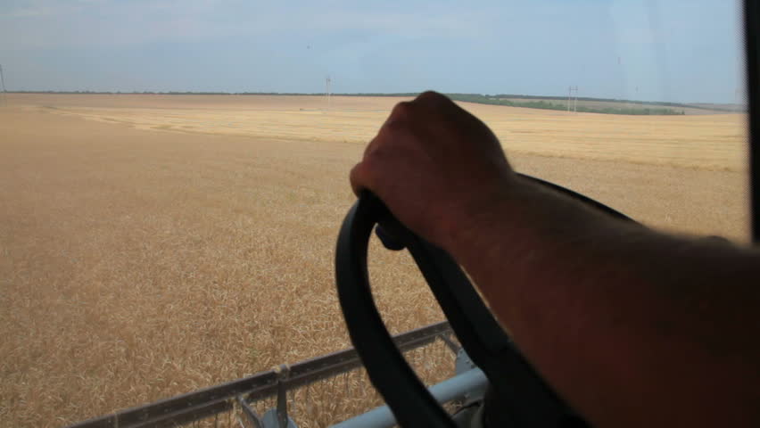 farmer driving combine harvester for harvesting wheat
