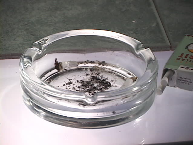 hand places cigarette in ashtray