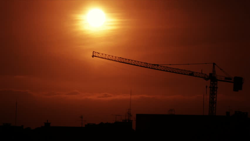 Time-lapse of a sunset behind a construction crane. 