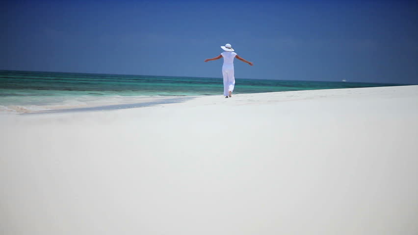 Elegant female reveling in the solitude of a beautiful white tropical beach