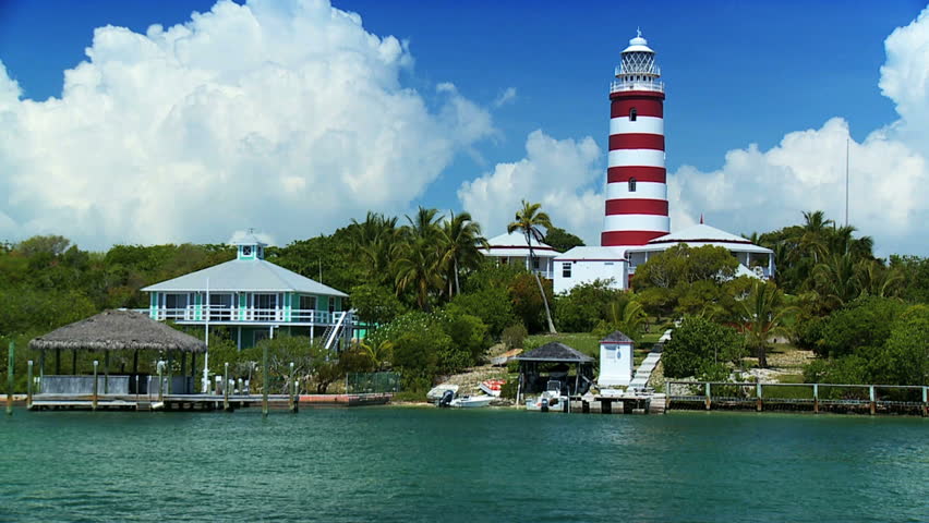 Lighthouse on a tropical holiday island surrounded by a turquoise sea and pleasure craft.