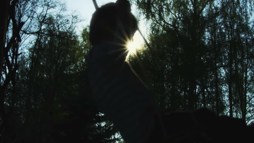 Silhouette of boy on swing - slow motion