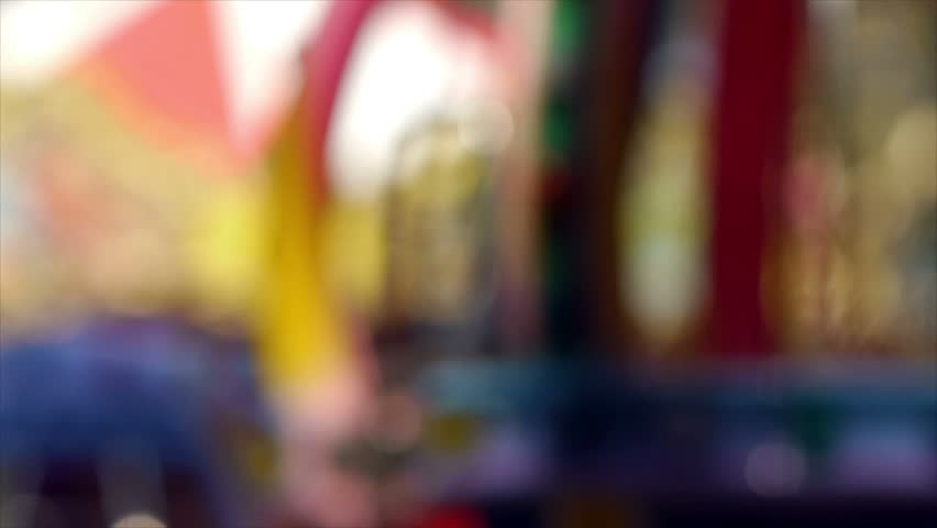 Carousel spinning in city park, blurred.