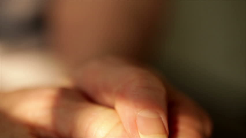 An older woman wringing her hands as if very anxious or worried.