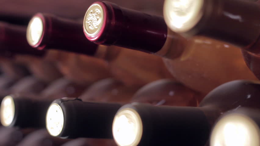 Dolly shot of wine bottles in an old wine cellar.