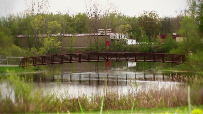 Jogger crossing red creek bridge going from right to left