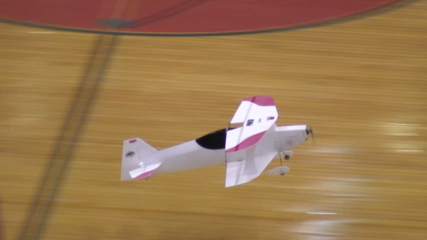 Radio-controlled foam model airplane performing aerobatic tricks at the competition venue