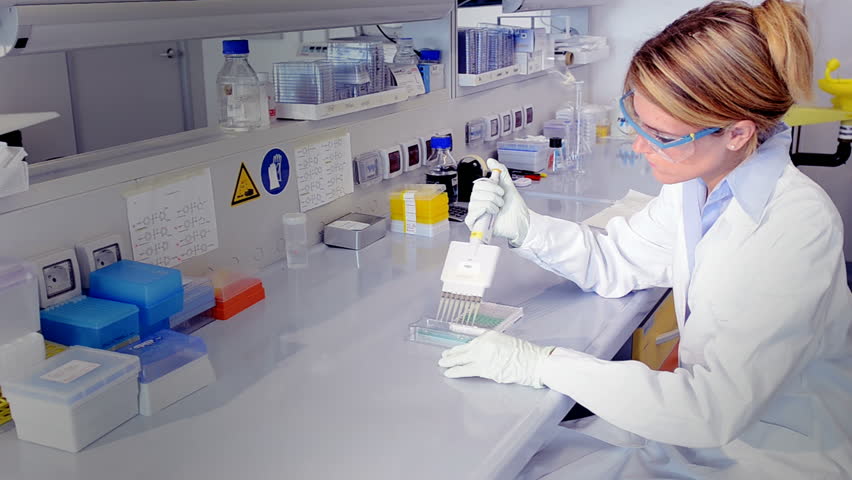 Researcher injecting liquid into a microplate; Full HD Photo jpeg