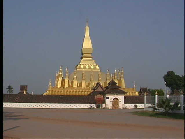 Motorcyclists make their way past the majestic golden Pha That Luang Temple in Vientiane, Laos.