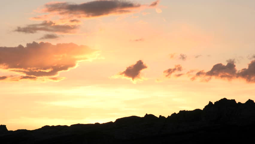 Bright orange colors in the golden-hour sky intensify and fade.