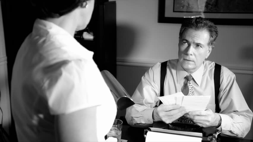 A scene set in the 1940's taken over the shoulder of a woman talking to a man sitting behind a desk who appears troubled by what she is telling him. Black and White, Film Noir