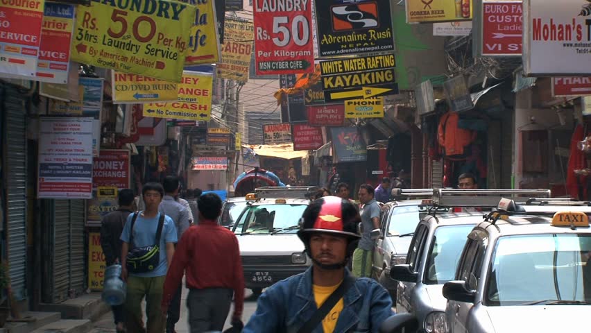 KATHMANDU - CIRCA 2010: People, cars and bikes circulate through the city circa 2010 in Kathmandu.
