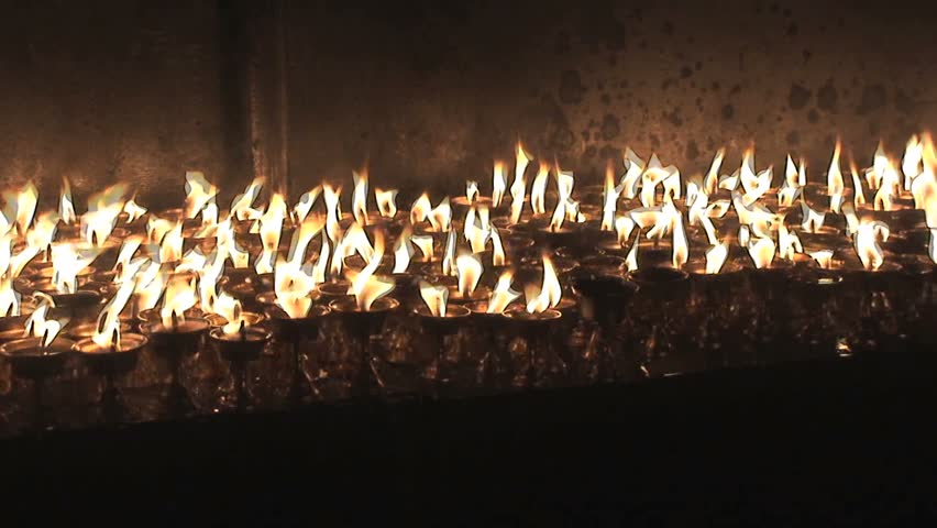 Rows of burning candles inside a temple in nepal