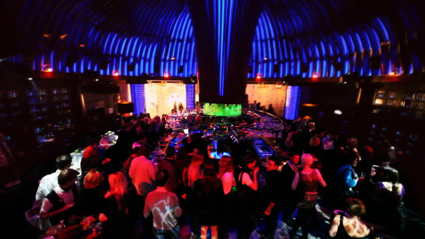 people at party of big night club with luminous ceiling in form of fungus