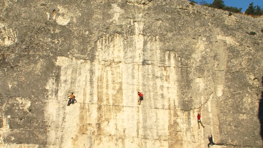 Group of athletes on the rock. A team of professional climbers conquer the steep mountain.