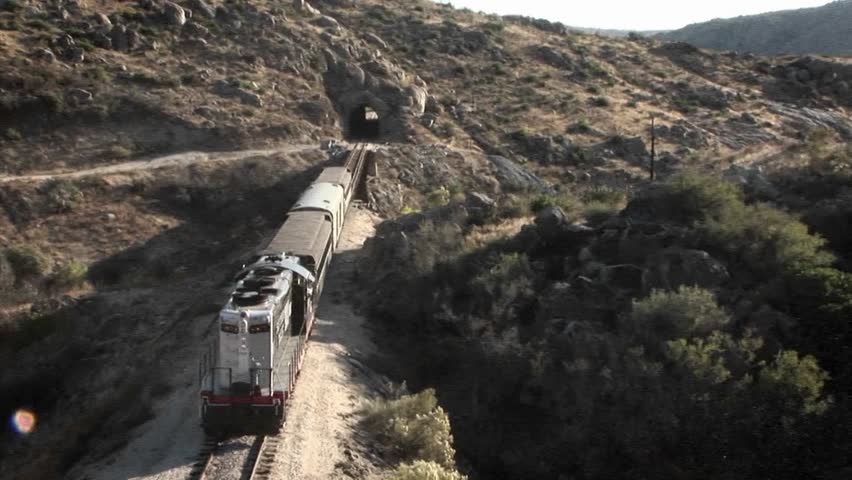 A train begins to enter into a tunnel.