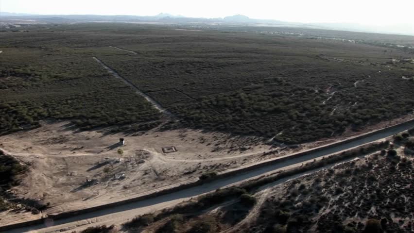 A daytime aerial view of a waterway traversing through a minimally developed landscape.
