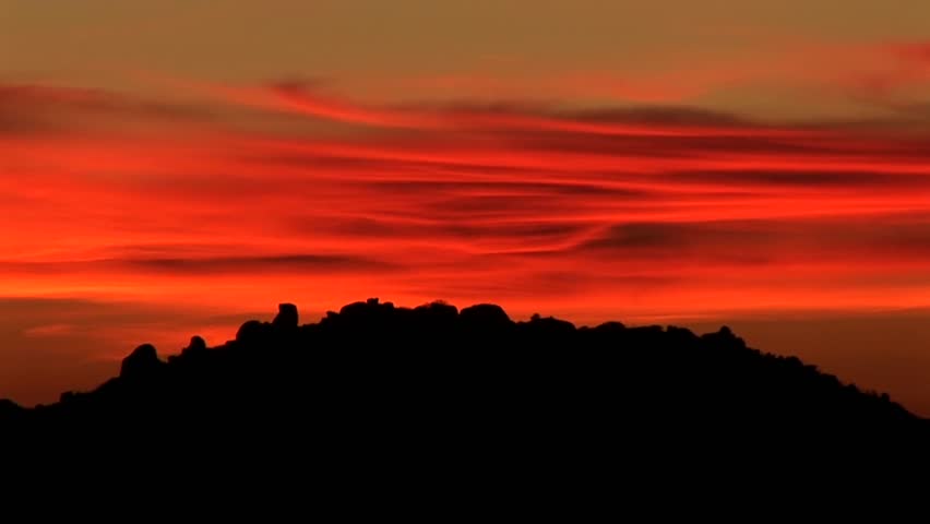 The sun has just gone down over a mountain.