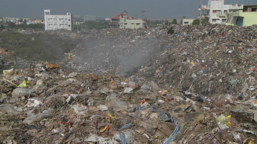 Smoke rises from burning rubbish in a large urban land-fill.