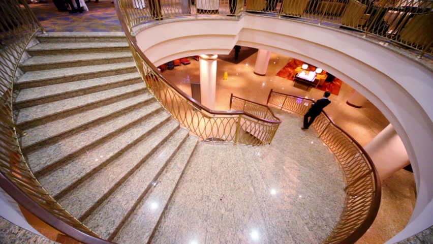 Man stand on marble circular stairs and speak cellphone
