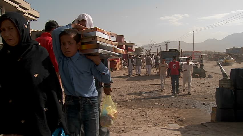 KABUL, AFGHANISTAN - CIRCA 2009: Slow-motion shot of people walking on dirt streets  circa 2009 in Kabul, Afghanistan. Afghanistan is an impoverished and least developed country, one of the world's poorest. 