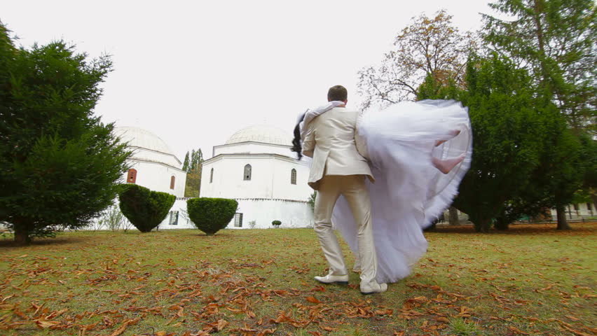 groom celebrating their wedding by spinning around the bride against the Muslim Mosque Bakhchisarai Palace (Hansaray, Khan's Palace) Bakhchisaray, Crimea, Ukraine