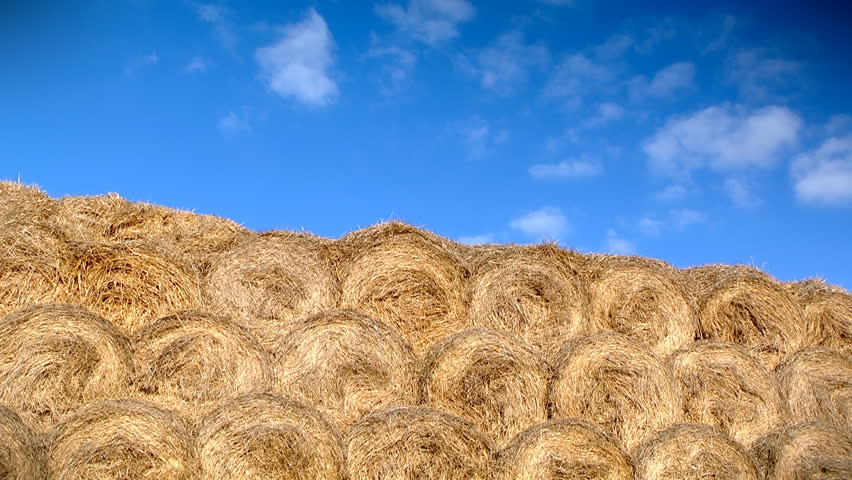 Cloudscape timelapse. Clear sky with white clouds over big haystack