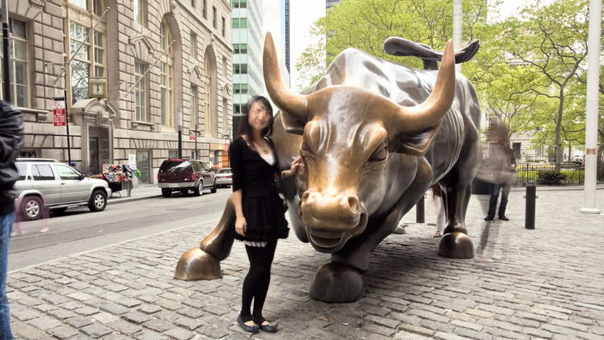 NEW YORK - MAY 7: (Timelapse View) Tourists have their pictures taken with the Charging Bull, May 7 2011 in NY. The Charging Bull sculpture is both a popular tourist destination which draws thousands of people a day, as well as "one of the most iconic ima