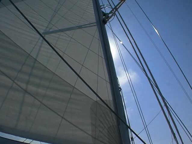 Yacht at sea, sails and sun, pan to cockpit 