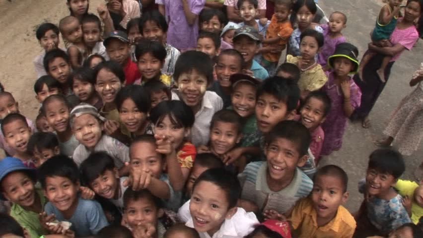MYANMAR - CIRCA 2009: A crowd of children smile and wave at the camera circa 2009 in Myanmar.