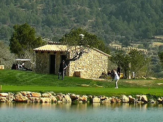 Golf, woman teeing off at the lake