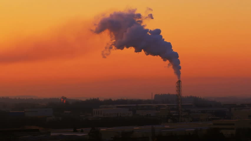 Sunrise silhouette of smoking factory