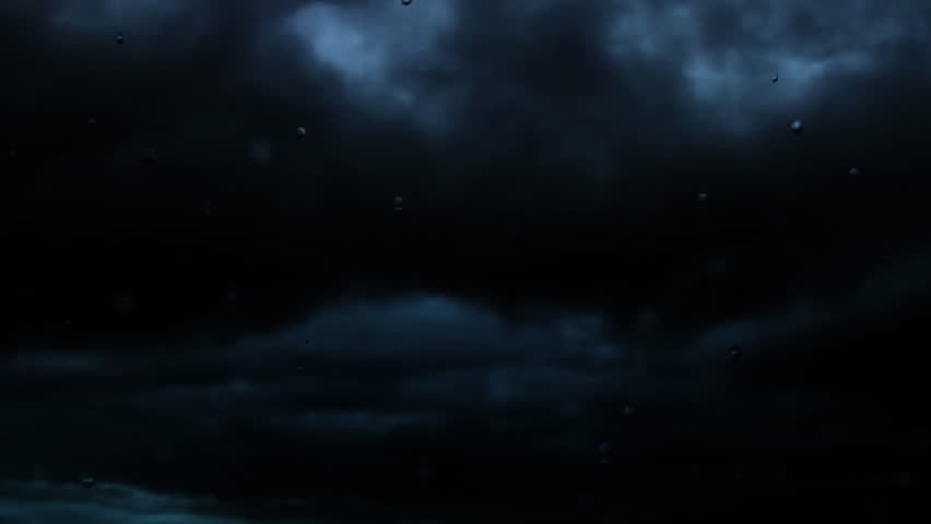 Stormy night looking through a pane of glass while lightning flashes