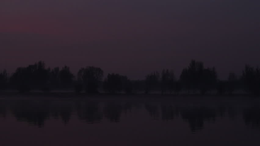 Large cargo barge passes by on the river IJssel in a sunset at the end of the day.