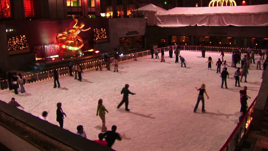 NEW YORK - CIRCA 2005: The camera shows skaters at night on the Rockefeller Center ice rink and then pans up the GE Building in New York, NY circa 2005
