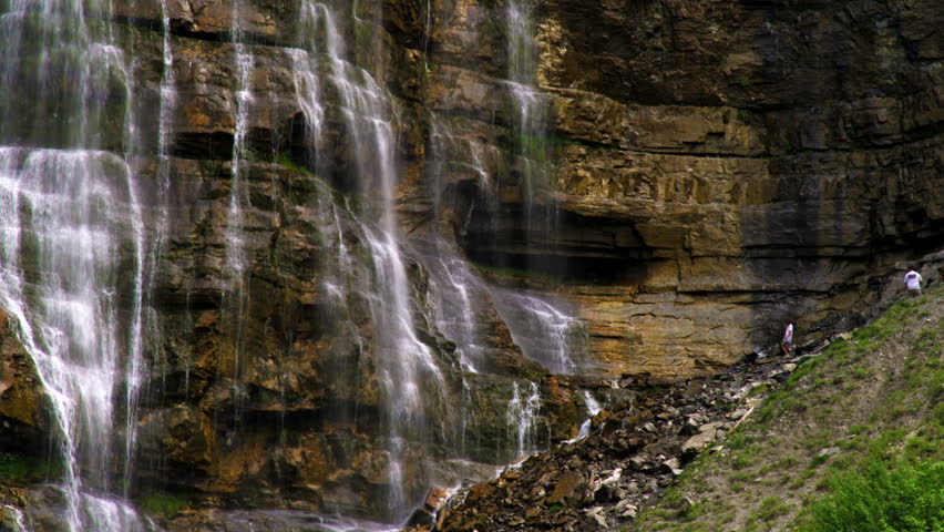 Bottom of Bridal Veil Falls in Provo Canyon, Utah.  People are climbing around the rocks at the base of the waterfall.