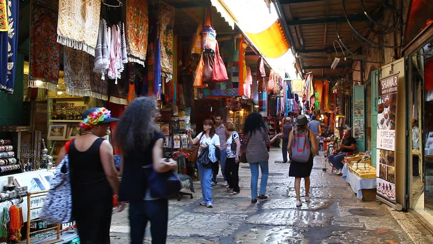 JERUSALEM, ISRAEL - CIRCA OCT 2011: Tourists look for souvenirs in a colorful alley of a bazaar market circa October 2011 in Jerusalem.