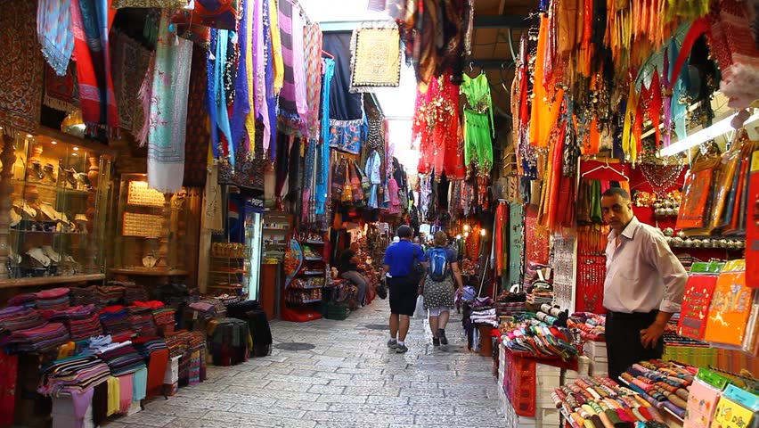 JERUSALEM, ISRAEL - CIRCA OCT 2011: Tourists look for souvenirs in a colorful alley of a bazaar market circa October 2011 in Jerusalem.