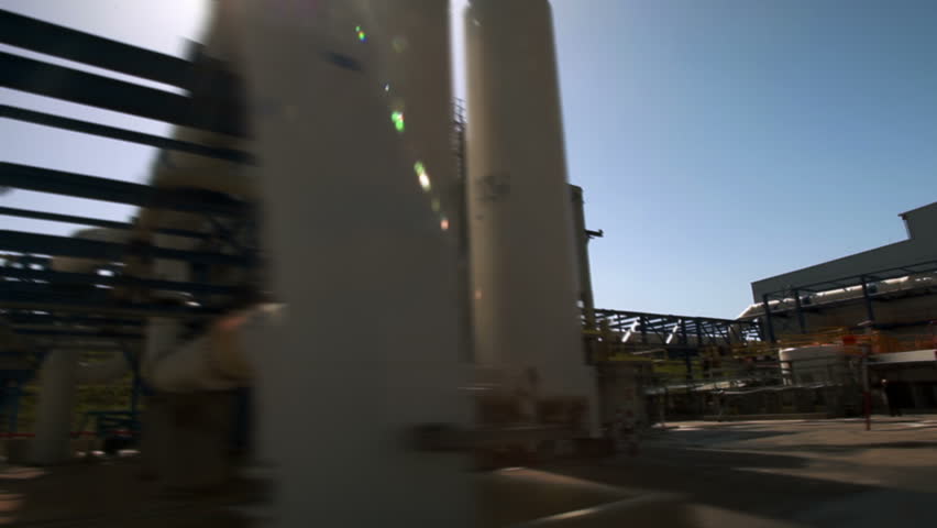 Silhouetted shot driving through the IDE Ashkelon Desalination plant in Israel, showing the water pipe and one of the buildings.