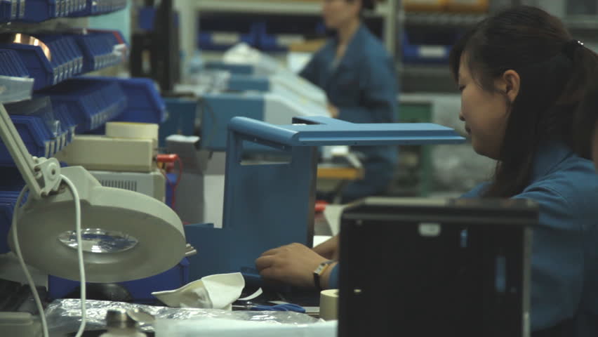 SHANGHAI, CHINA - CIRCA APRIL 2011: Chinese workers assemble parts for the Thermo Fisher Scientific company circa April 2011 in Shanghai. 