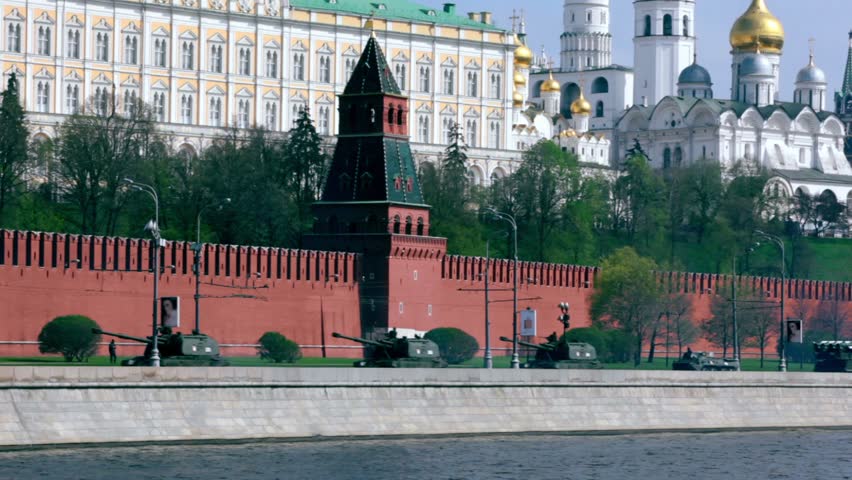 Tanks and other military hardware ride by quay of Moscow Kremlin, red brick walls and Ivan Great Bell Tower. Victory Day 1945 year. Russia.