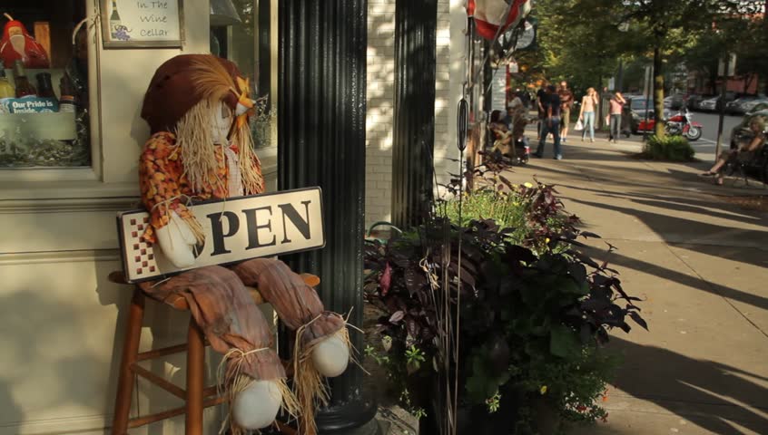COOPERSTOWN, NY - SEPT 24, 2011: A scarecrow holds an "Open" sign outside a main shop on September 24, 2011 in Cooperstown.
