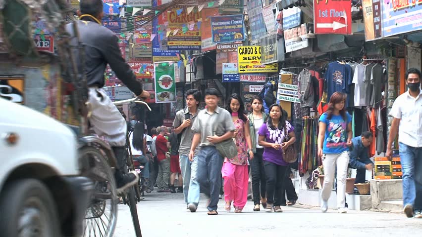 NEPAL - CIRCA MAY, 2011: Busy narrow street packed with cars, tricycle rickshaws and pedestrians.