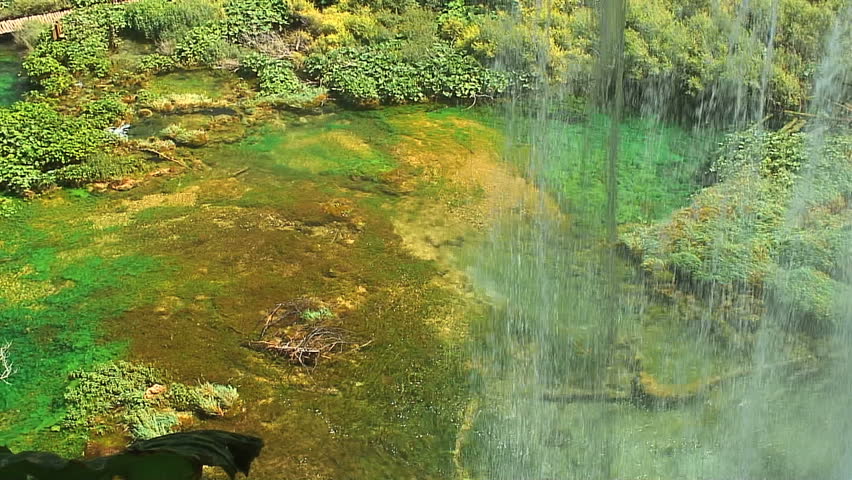Slow Pan From Waterfall to Lake with Tourists