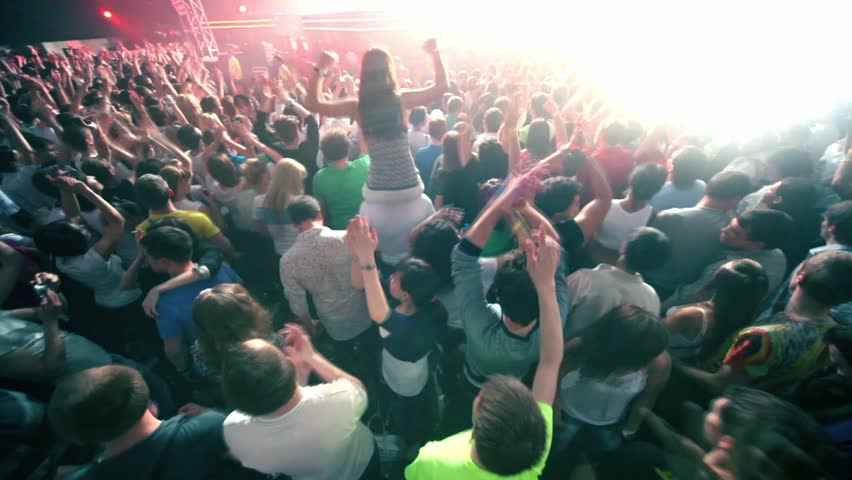 MOSCOW - MAY 6: Girl sits on mans shoulders among people at rave party with DJ Armin Van Buuren on stage, on May 6, 2011 in Moscow, Russia.