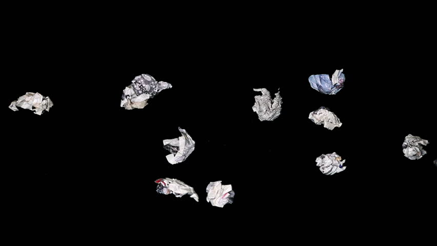 Paper rubbish and garbage cast against black background. Time lapse. 