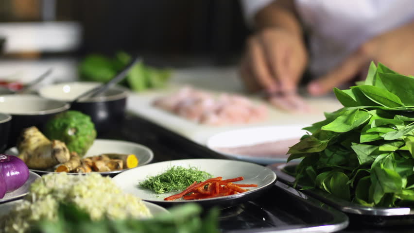 Close-up of chef hands cooking and preparing Asian food and sushi in restaurant kitchen. Rack focus
