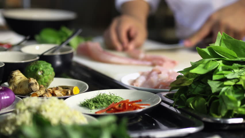 Professional chef cooking, working and preparing Asian food and sushi in restaurant kitchen. Rack focus