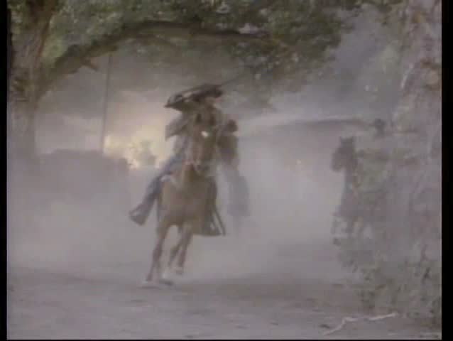 Bandits on horseback leaving burning village